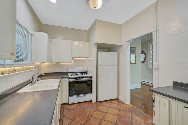 1677 4th St, Sarasota, FL 34236 - kitchen featuring a baseboard radiator, a sink, white appliances, and dark countertops