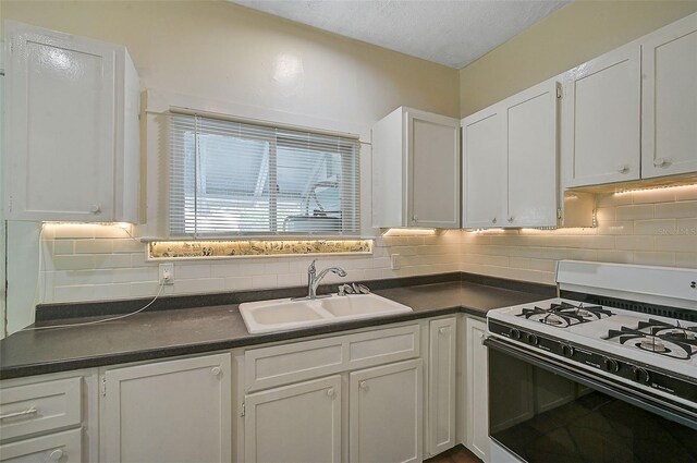 1677 4th St, Sarasota, FL 34236 - kitchen with a sink, white range with gas cooktop, white cabinetry, and dark countertops