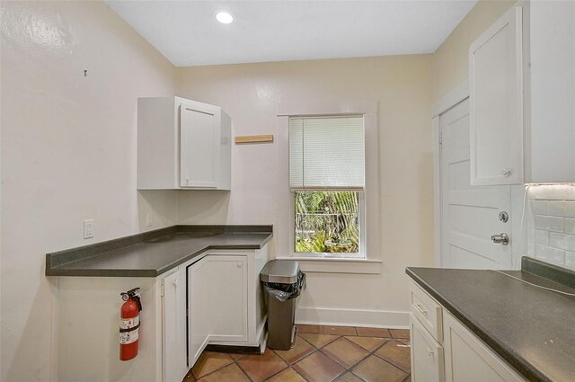 1677 4th St, Sarasota, FL 34236 - kitchen featuring baseboards, tile patterned floors, white cabinetry, dark countertops, and decorative backsplash