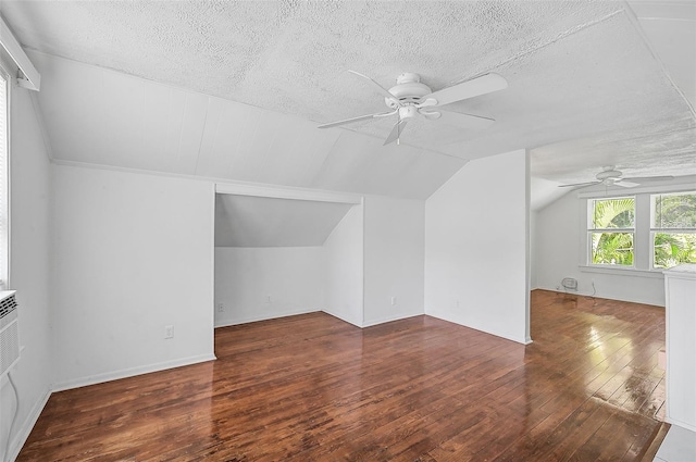 additional living space with ceiling fan, a textured ceiling, lofted ceiling, and dark wood-type flooring