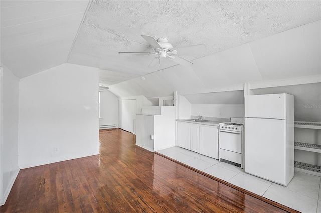 additional living space featuring ceiling fan, sink, a textured ceiling, light hardwood / wood-style flooring, and vaulted ceiling