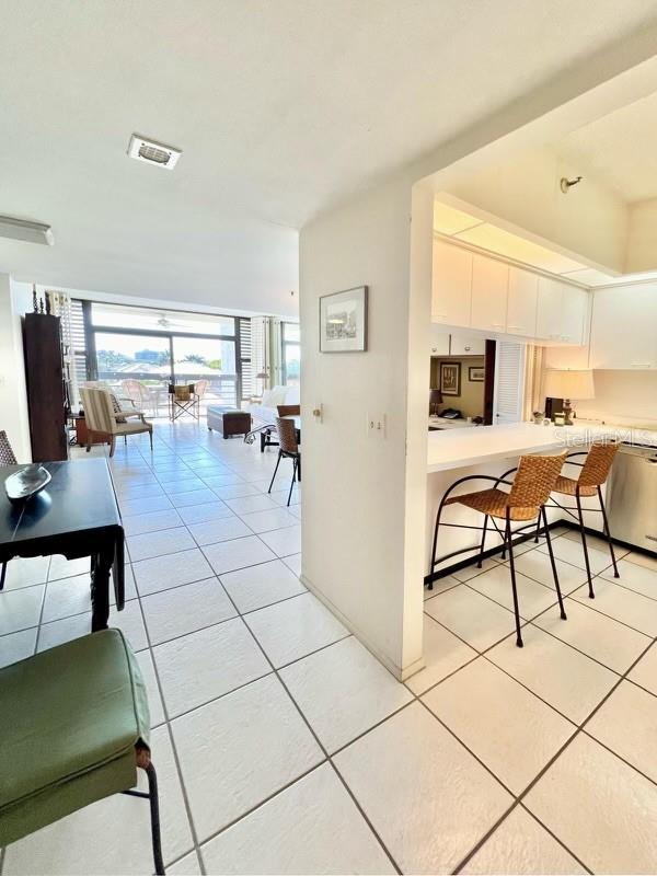 interior space with light tile patterned flooring and white cabinets