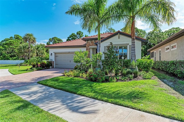 mediterranean / spanish house with a garage and a front lawn