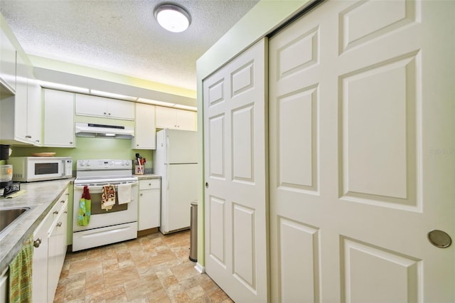 kitchen featuring white cabinets, white appliances, and a textured ceiling