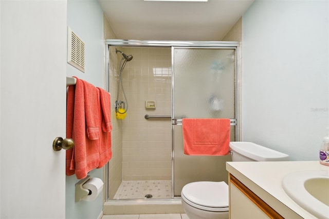 bathroom featuring vanity, tile patterned flooring, toilet, and an enclosed shower