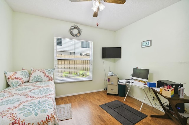 home office with light hardwood / wood-style floors and ceiling fan