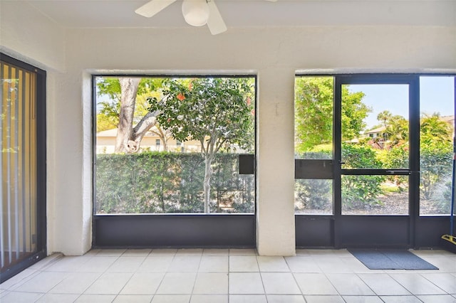 unfurnished sunroom featuring ceiling fan