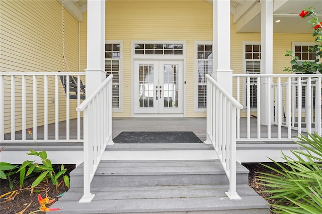 view of exterior entry featuring covered porch and french doors