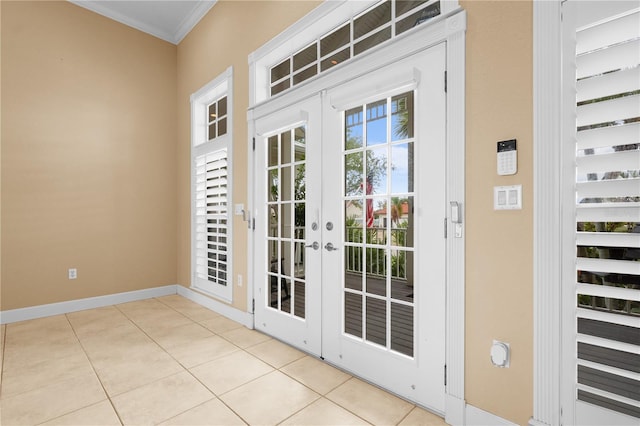 entryway featuring light tile patterned floors, crown molding, and french doors