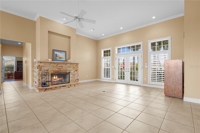 unfurnished living room with light tile patterned floors, crown molding, french doors, and a fireplace