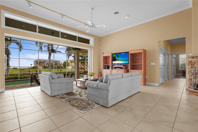 living room featuring crown molding, a healthy amount of sunlight, light tile patterned floors, and ceiling fan