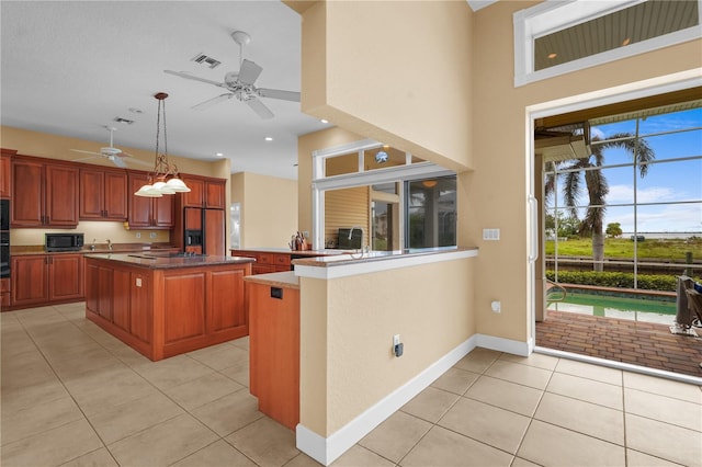 kitchen featuring paneled built in fridge, hanging light fixtures, light tile patterned floors, and a kitchen island