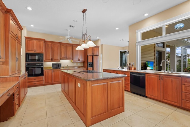 kitchen with stone countertops, sink, light tile patterned floors, a kitchen island, and black appliances