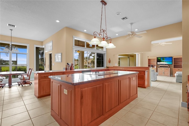 kitchen with a kitchen island, hanging light fixtures, kitchen peninsula, and light tile patterned floors