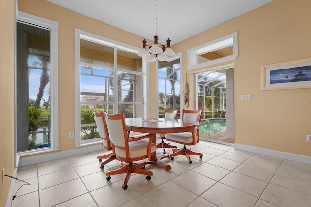 tiled dining room featuring an inviting chandelier and a wealth of natural light