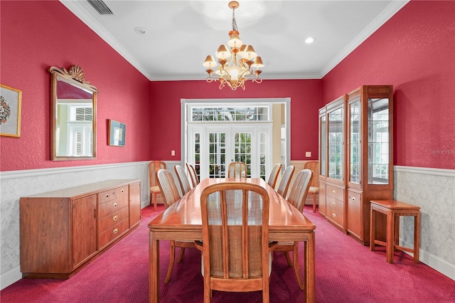 carpeted dining space with a notable chandelier, french doors, and ornamental molding