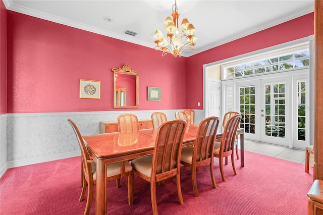 carpeted dining space with crown molding, a notable chandelier, and french doors