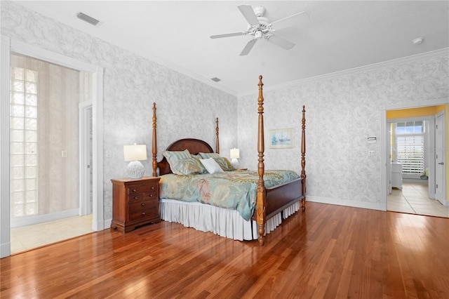 bedroom featuring ceiling fan, ornamental molding, and wood-type flooring