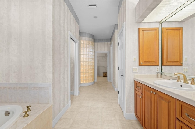 bathroom featuring vanity and a relaxing tiled tub