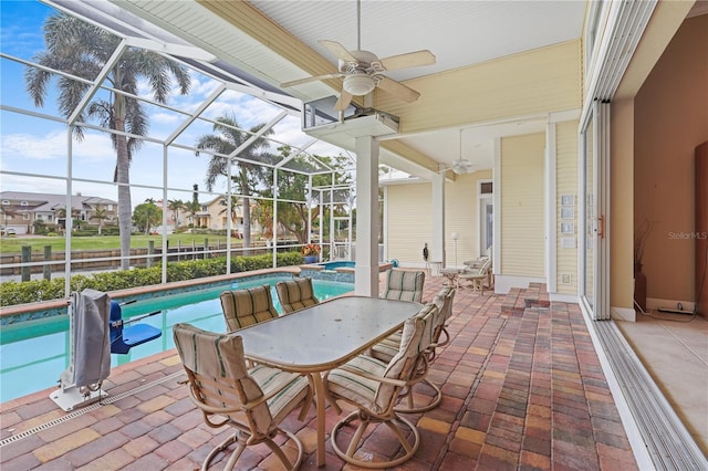 view of patio / terrace featuring a pool with hot tub, ceiling fan, and glass enclosure