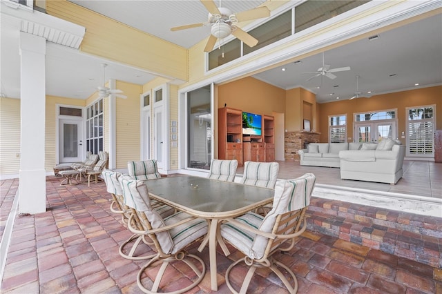 view of patio featuring ceiling fan, exterior kitchen, and an outdoor living space