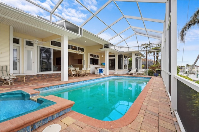 view of swimming pool featuring glass enclosure, an in ground hot tub, a patio, and ceiling fan