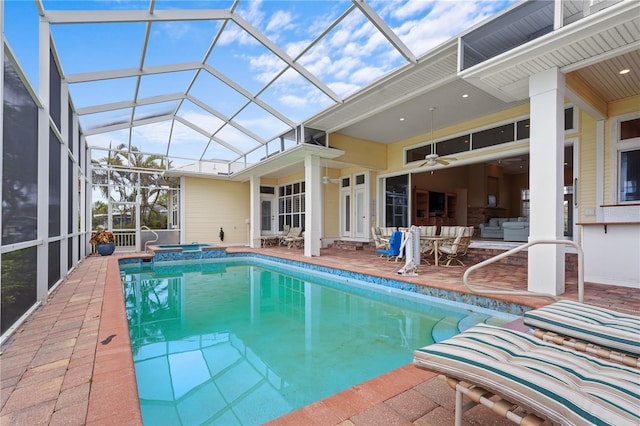 view of swimming pool with an in ground hot tub, a patio, glass enclosure, ceiling fan, and an outdoor hangout area