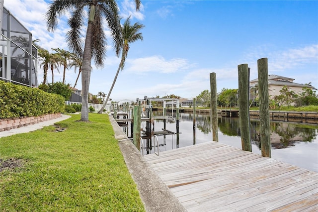 dock area with a lanai, a lawn, and a water view