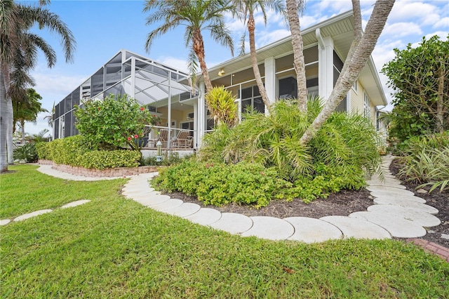 rear view of property featuring a lanai and a yard