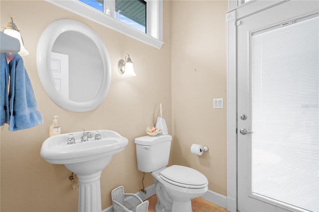 half bath featuring toilet and baseboards