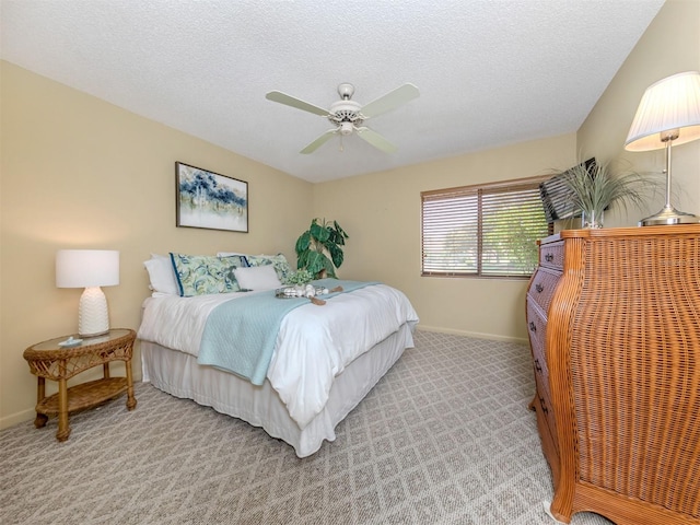 carpeted bedroom with ceiling fan and a textured ceiling