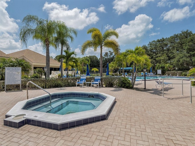 view of swimming pool with a community hot tub and a patio area