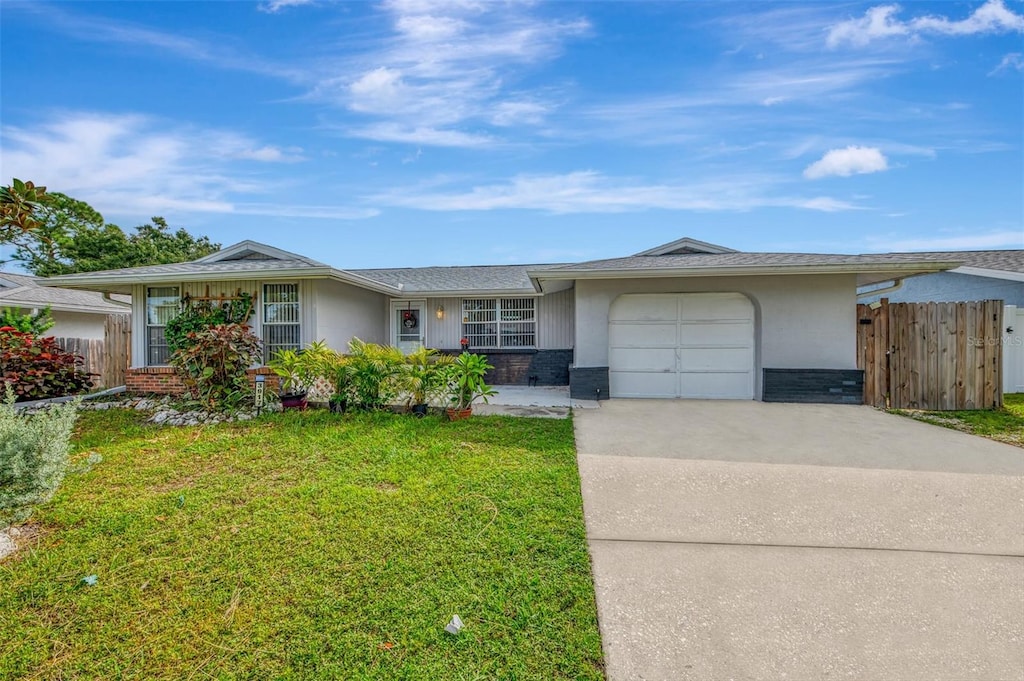 ranch-style home with a garage and a front lawn