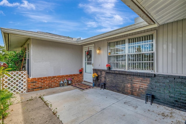 view of exterior entry with a patio area