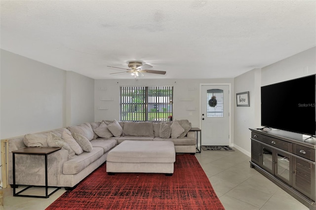 living room with a textured ceiling, light tile patterned floors, and ceiling fan