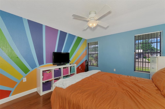 bedroom with ceiling fan and hardwood / wood-style flooring