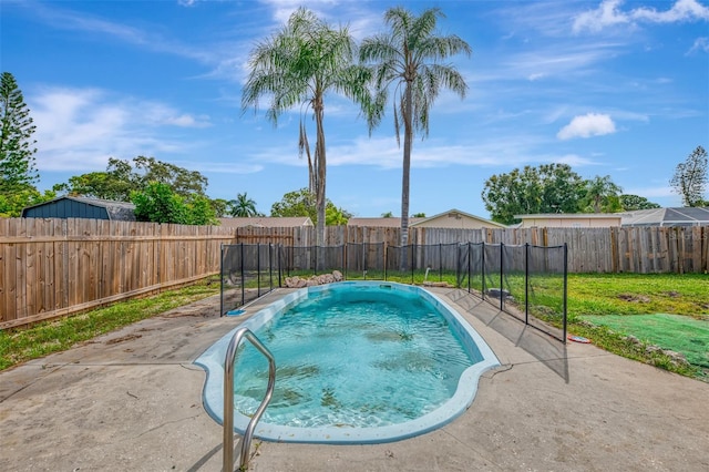 view of pool with a patio and a yard