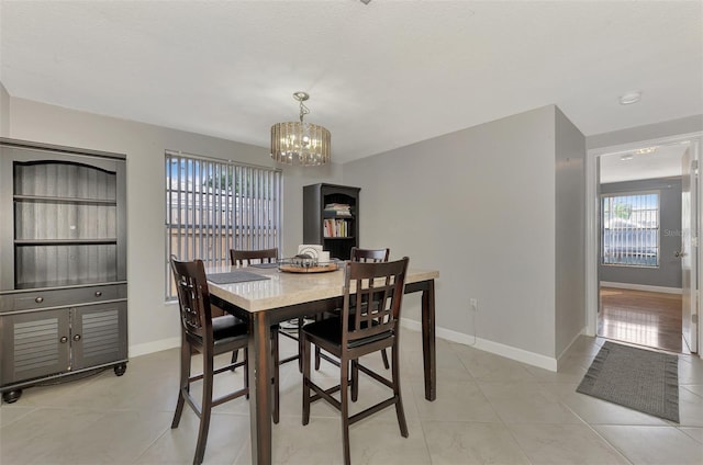 tiled dining space featuring an inviting chandelier