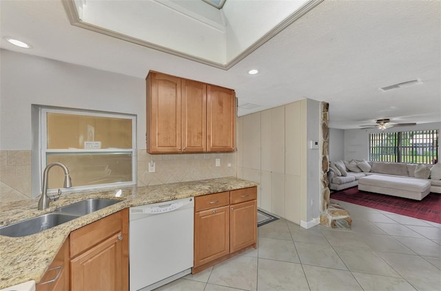 kitchen featuring light stone counters, dishwasher, a textured ceiling, ceiling fan, and sink