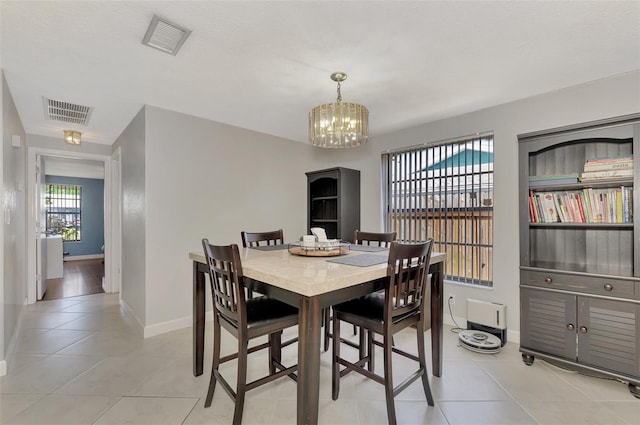 dining area with an inviting chandelier and light tile patterned floors