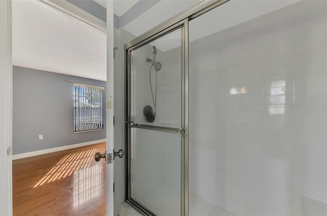 bathroom with a shower with door and hardwood / wood-style floors