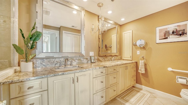 bathroom featuring tile patterned floors, a chandelier, vanity, and toilet