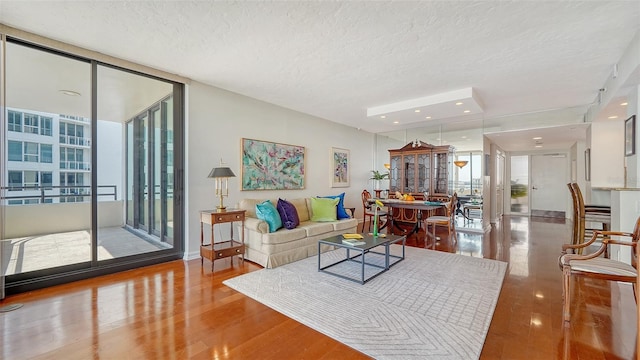 living room featuring floor to ceiling windows, a textured ceiling, and hardwood / wood-style flooring