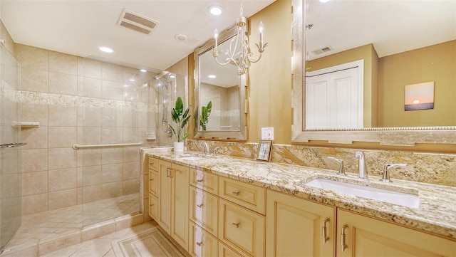 bathroom featuring tiled shower, vanity, and tile patterned flooring