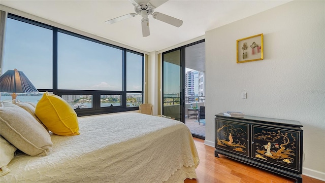 bedroom with ceiling fan, floor to ceiling windows, hardwood / wood-style floors, and access to outside