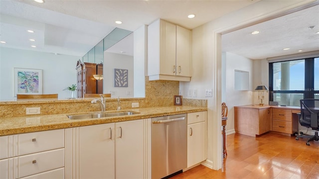 kitchen with light stone counters, tasteful backsplash, dishwasher, light wood-type flooring, and sink