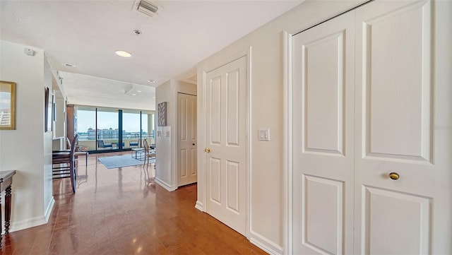 hall with wood-type flooring and floor to ceiling windows