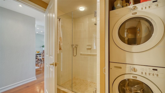 1255 N Gulfstream Ave Unit 1003, Sarasota, FL 34236 - full bathroom featuring stacked washer and clothes dryer, a stall shower, wood finished floors, and baseboards
