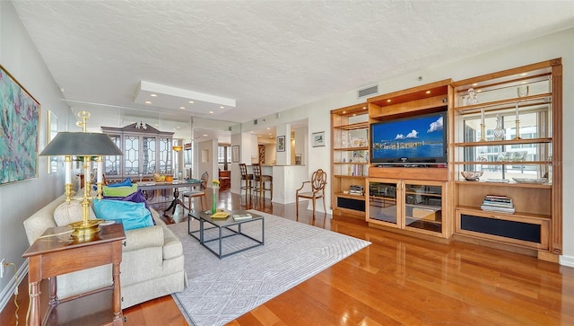 living room with a textured ceiling and hardwood / wood-style floors