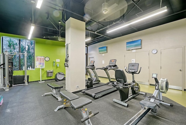 exercise room featuring a towering ceiling